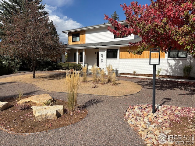 traditional-style home featuring covered porch and brick siding