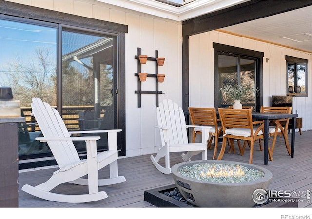 deck with an outdoor fire pit and outdoor dining area