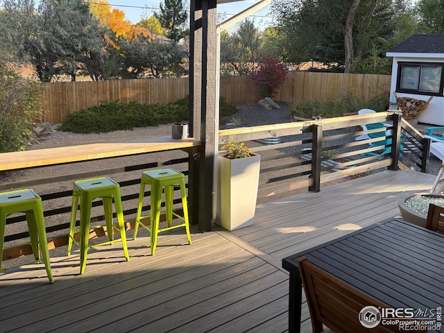 wooden terrace with a fenced backyard