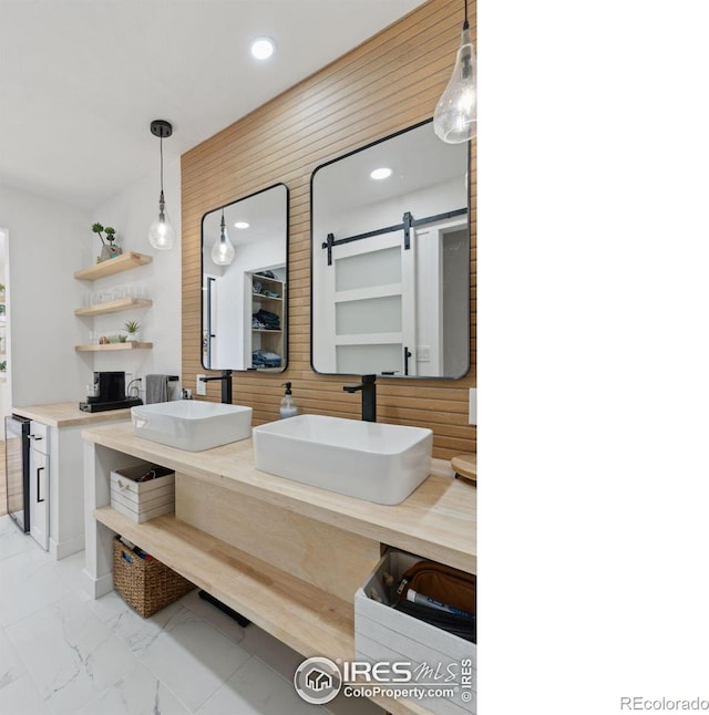 full bath featuring marble finish floor, double vanity, a sink, and recessed lighting