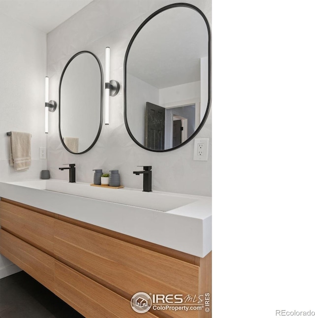 bathroom with a sink and double vanity