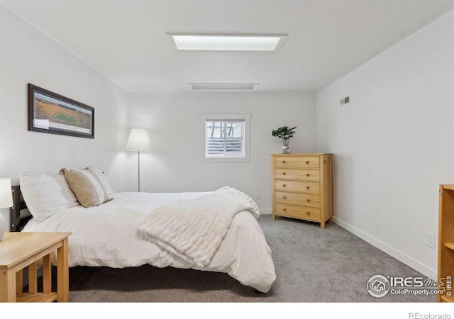 carpeted bedroom featuring attic access, visible vents, and baseboards