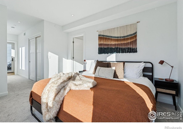 bedroom featuring light colored carpet and a closet