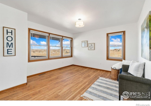 sitting room with light hardwood / wood-style floors and a healthy amount of sunlight