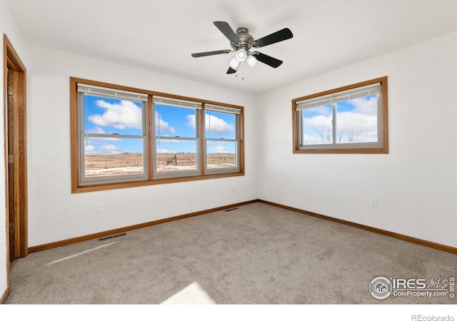 carpeted spare room with ceiling fan