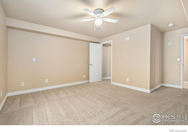 spare room with ceiling fan and light colored carpet