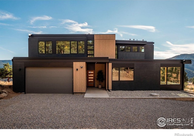 modern home featuring a garage and a mountain view