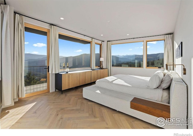 bedroom featuring a mountain view, light parquet floors, and access to exterior