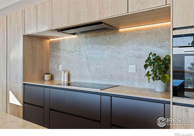 kitchen with tasteful backsplash, black electric stovetop, range hood, and light brown cabinetry