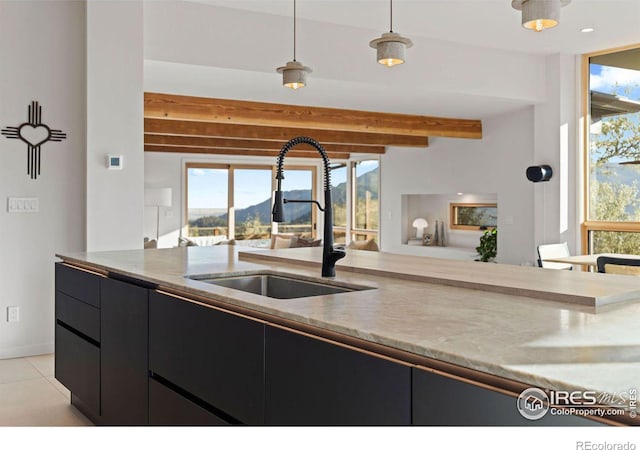 kitchen featuring beamed ceiling, sink, hanging light fixtures, light tile patterned floors, and a mountain view