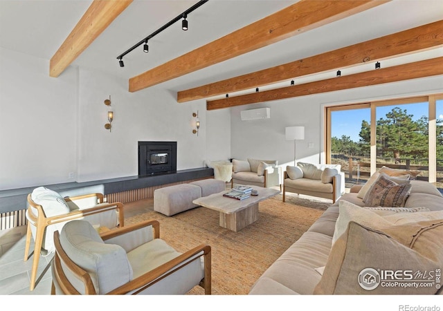 living room featuring beamed ceiling, rail lighting, and a wall mounted AC