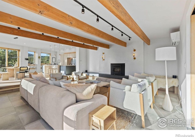 living room featuring beamed ceiling, light tile patterned flooring, and a wall unit AC