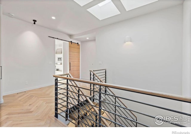 hall featuring a skylight, parquet flooring, and a barn door