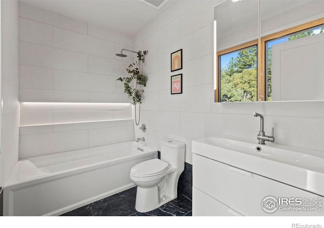 full bathroom featuring toilet, tiled shower / bath, tile walls, vanity, and backsplash