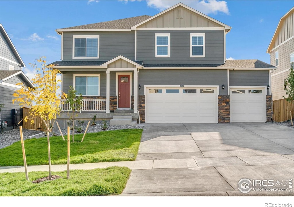 craftsman inspired home featuring a front yard, a garage, and a porch