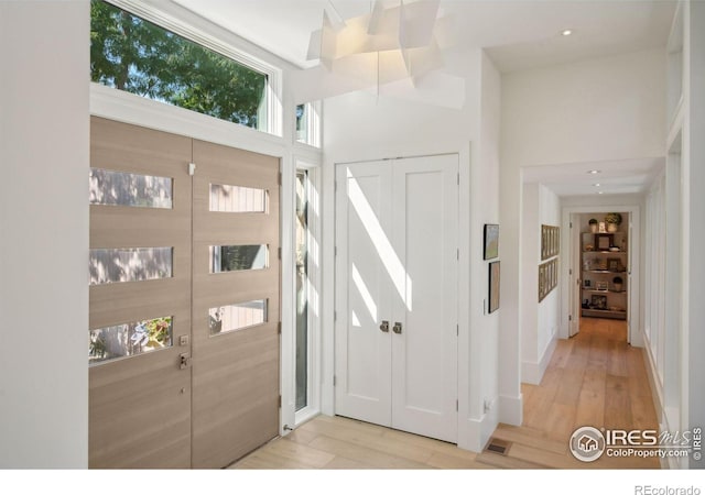 foyer entrance featuring a high ceiling and light hardwood / wood-style flooring