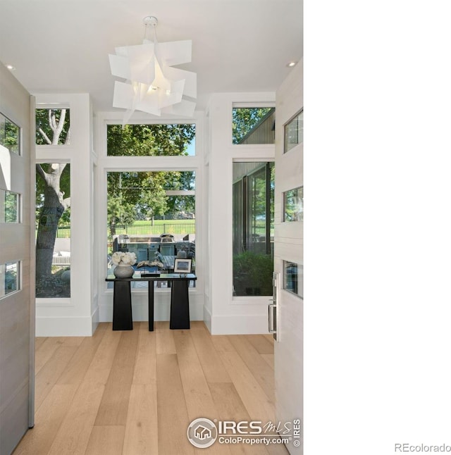 interior space featuring an inviting chandelier, light hardwood / wood-style flooring, and plenty of natural light