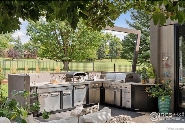 view of patio with exterior kitchen, grilling area, and sink