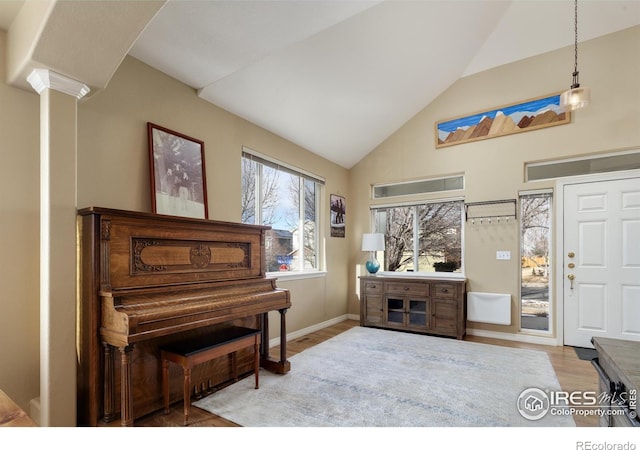 misc room featuring lofted ceiling, decorative columns, and light hardwood / wood-style flooring