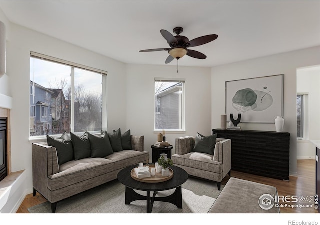 living area with a ceiling fan and wood finished floors