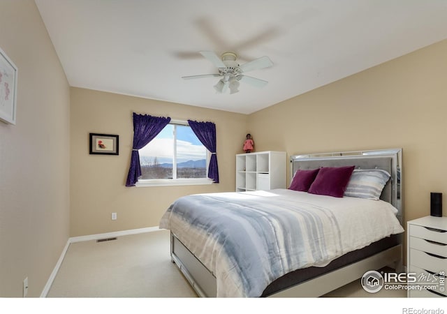 carpeted bedroom with visible vents, baseboards, lofted ceiling, and a ceiling fan