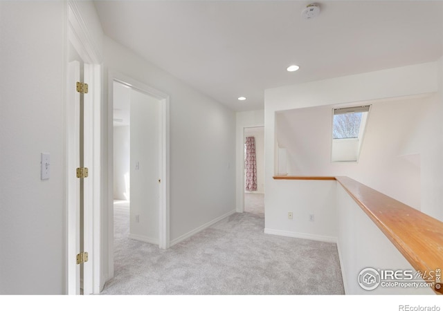 corridor featuring an upstairs landing, recessed lighting, carpet, a skylight, and baseboards