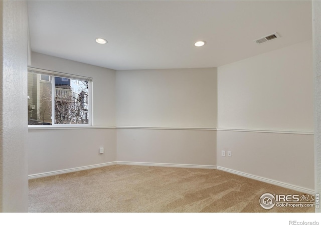 carpeted spare room featuring recessed lighting, visible vents, and baseboards