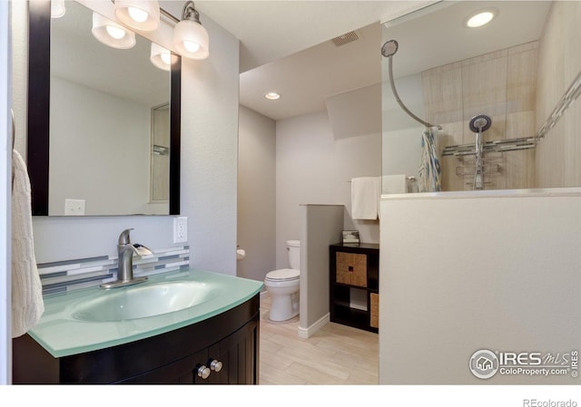 bathroom featuring visible vents, toilet, wood finished floors, a shower with shower curtain, and vanity