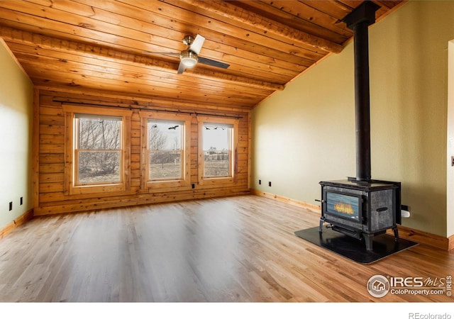 unfurnished living room with wood ceiling, light hardwood / wood-style flooring, ceiling fan, vaulted ceiling with beams, and a wood stove