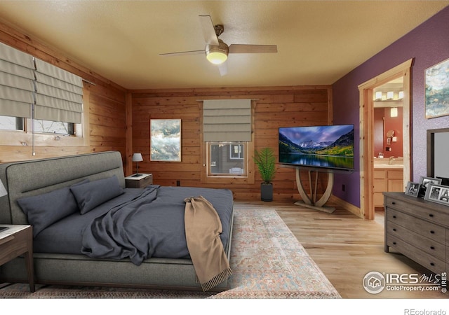 bedroom with ceiling fan, ensuite bath, and light hardwood / wood-style flooring