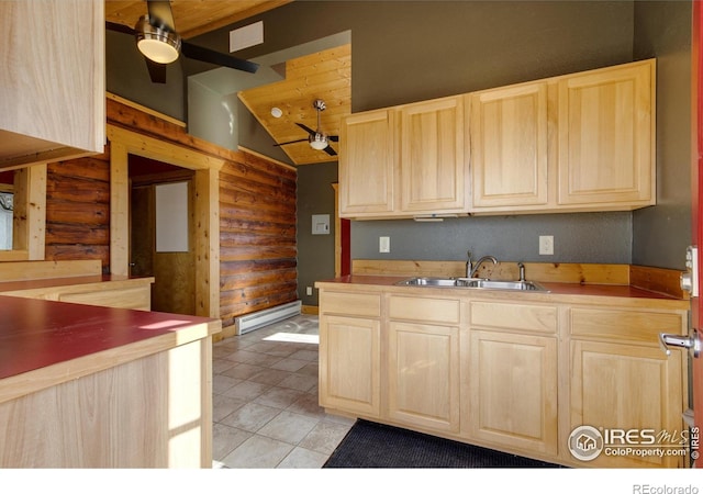 kitchen with sink, ceiling fan, rustic walls, and a baseboard heating unit