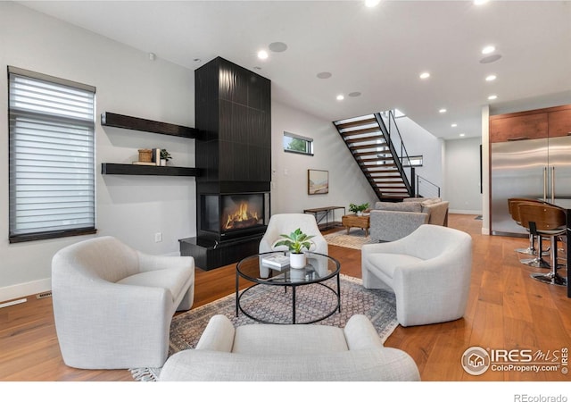 living room featuring a large fireplace and light wood-type flooring