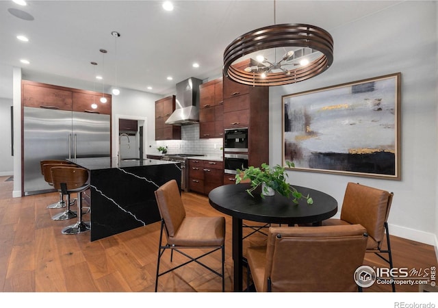 dining area featuring an inviting chandelier, light wood-type flooring, and sink