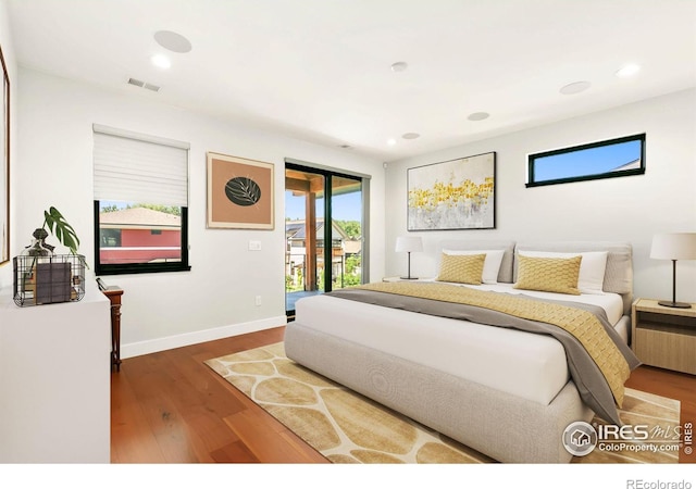 bedroom with dark hardwood / wood-style flooring and access to exterior