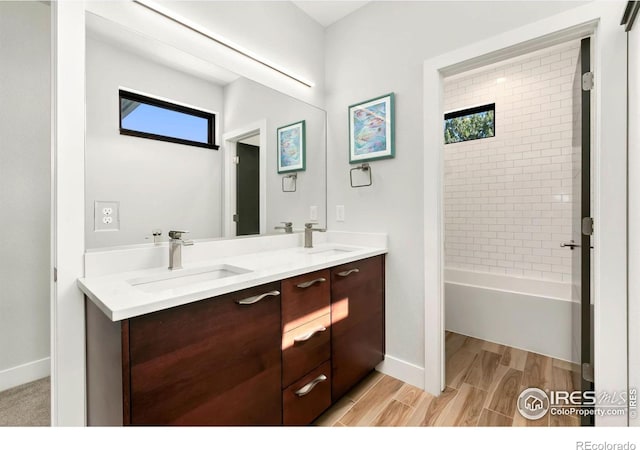 bathroom with tiled shower / bath combo, vanity, and hardwood / wood-style flooring