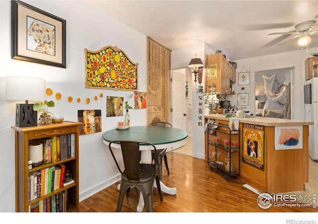 dining area featuring light wood-type flooring and ceiling fan