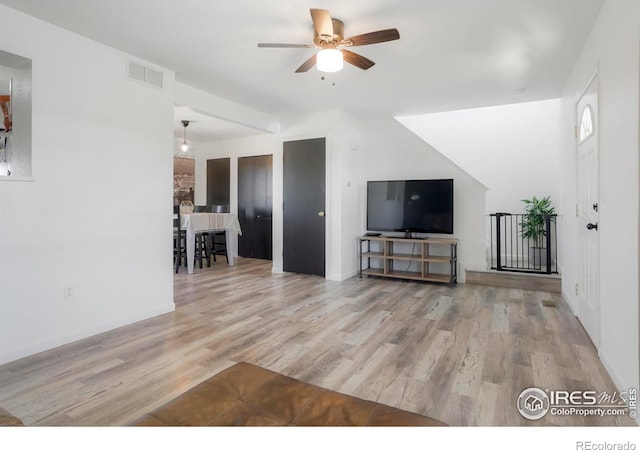 unfurnished living room with light wood-type flooring and ceiling fan