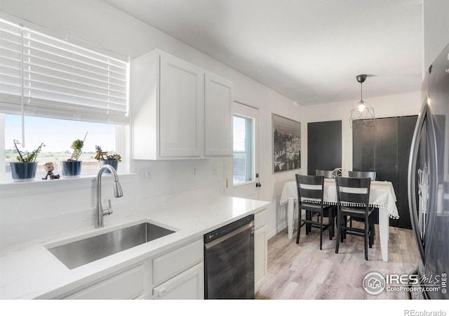 kitchen featuring white cabinets, black dishwasher, decorative light fixtures, and sink