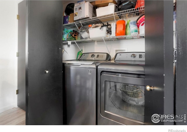 laundry room with light hardwood / wood-style floors and washer and clothes dryer