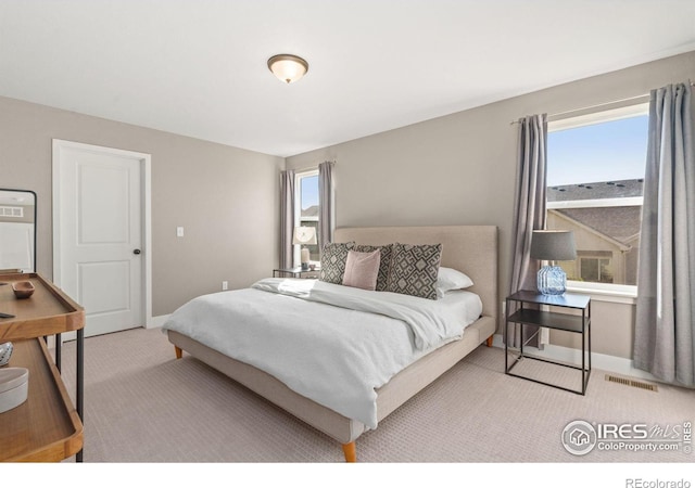 carpeted bedroom featuring multiple windows