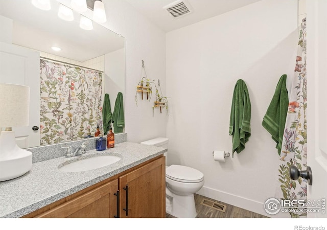 bathroom featuring toilet, wood-type flooring, and vanity