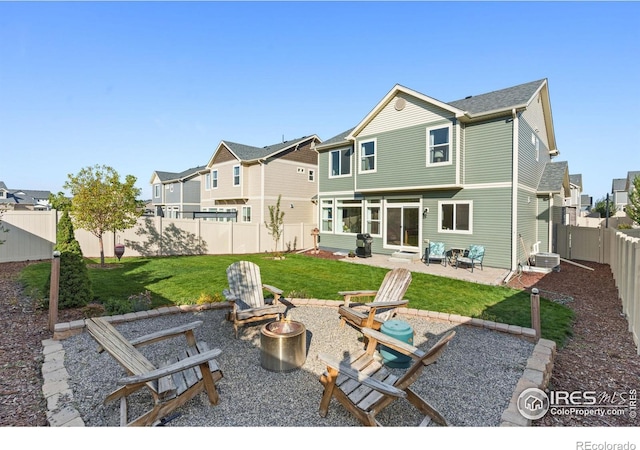 back of property with a patio, a lawn, a fire pit, and central AC