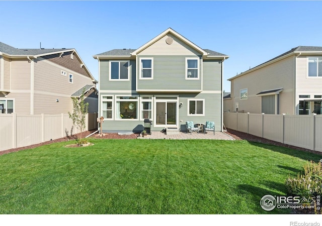 back of house with a patio area and a lawn