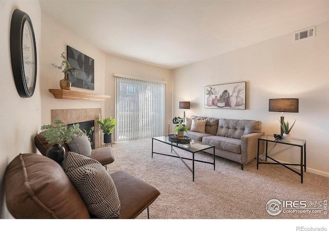 living room with a fireplace and carpet