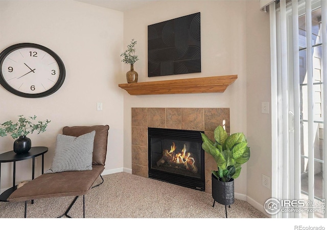 living area with a tiled fireplace and carpet floors