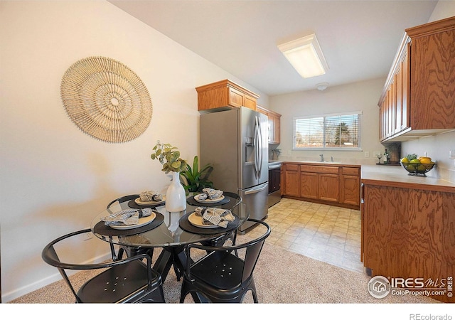 kitchen featuring sink, range, and stainless steel fridge