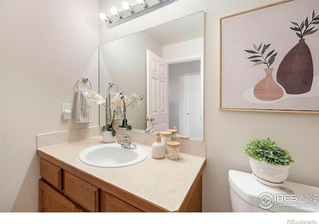 bathroom featuring toilet and vanity