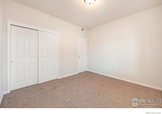 unfurnished bedroom featuring a closet and carpet flooring