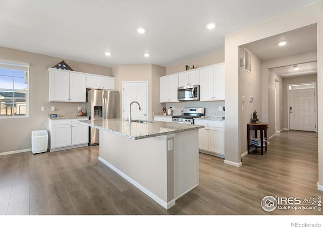 kitchen with appliances with stainless steel finishes, white cabinetry, and sink