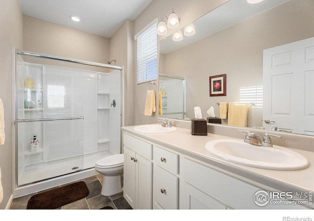 bathroom with toilet, tile patterned flooring, a shower with shower door, and vanity